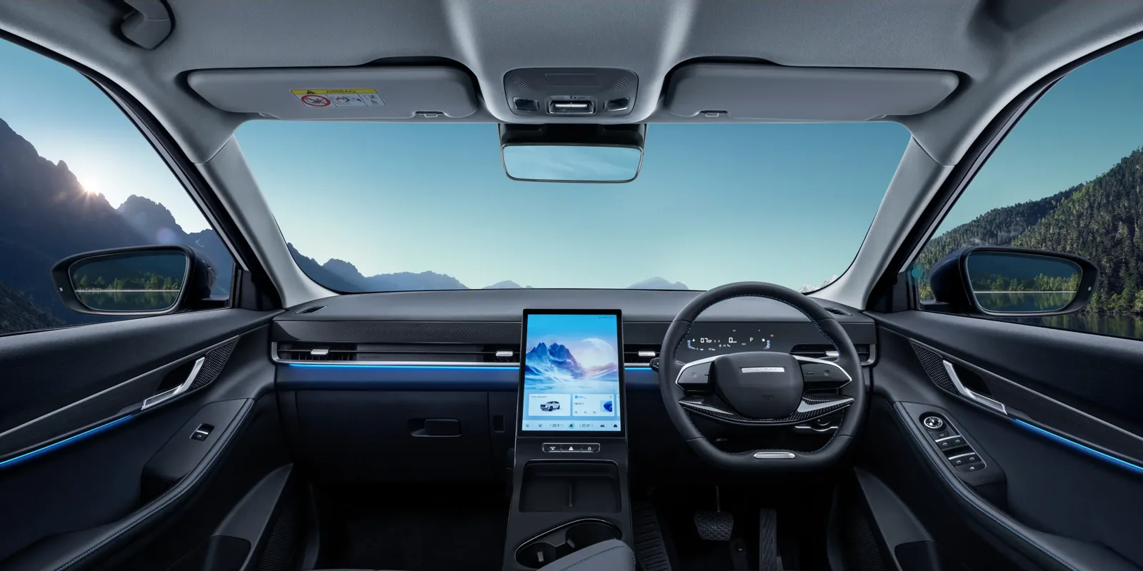 Jaecoo J5 EV dashboard, centre touchscreen and steering wheel, mountains through the windscreen.